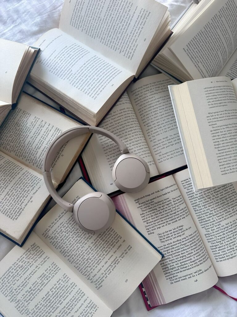 “Stack of books and headphones for self-improvement reading”
